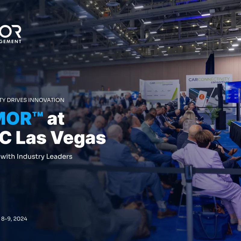 Armor™ A room filled with people sitting at tables and chairs. A speaker is standing up front, speaking to the crowd. The