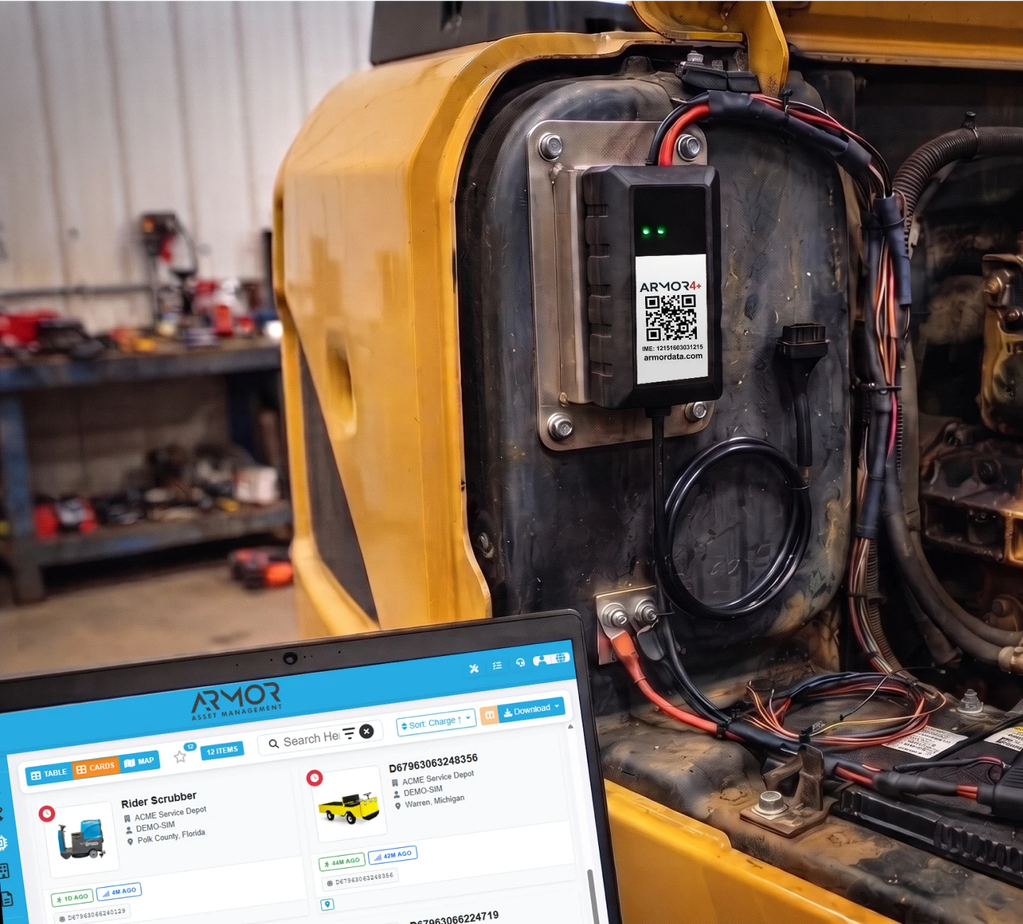 ARMOR 4+™ hardware device securely mounted on a yellow heavy machinery engine bay alongside a laptop displaying the ARMOR™ management dashboard.