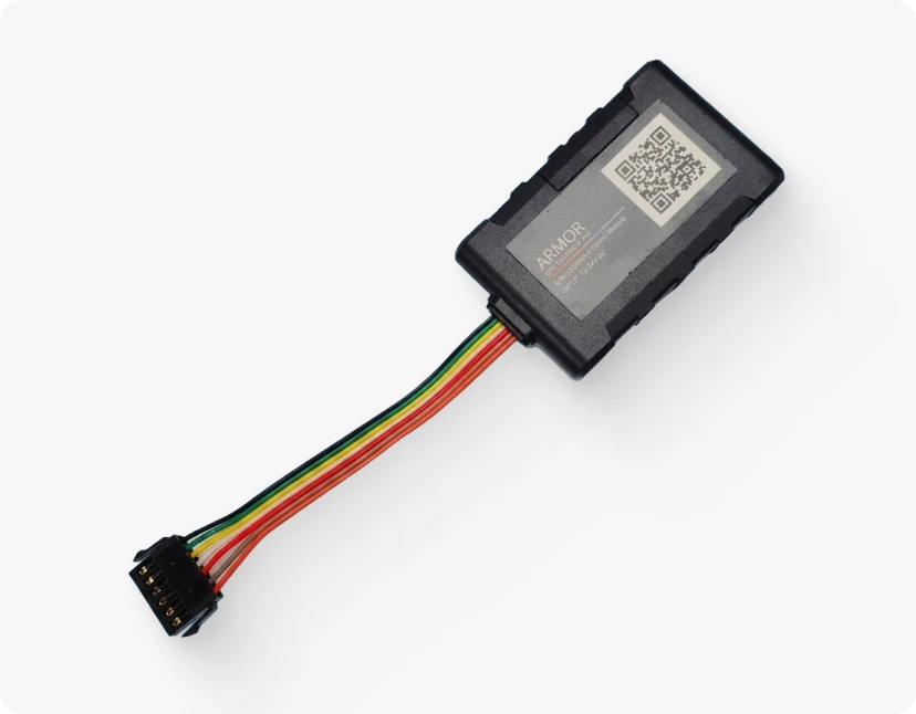 A small, rectangular device with a label and a QR code, connected to a series of wires, representing the ARMOR™ device and